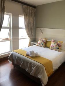 a bedroom with a large bed with two pillows at 314 on Clark Guest House in Pretoria