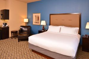 a hotel room with a large bed and a chair at Holiday Inn Express Hotel & Suites Wichita Falls, an IHG Hotel in Wichita Falls