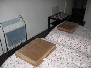 two beds with towels on top of them in a room at Anthony's Place in Almada