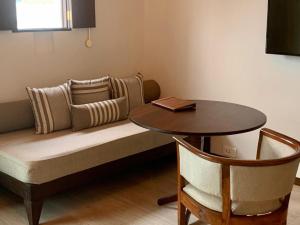 ein Sofa mit einem Tisch, einem Tisch und Stühlen in der Unterkunft Marasa Sarovar Premiere, Bodhgaya in Bodh Gaya