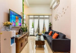 sala de estar con sofá azul y TV en 今古安民宿 - 步行東大門夜市3分鐘, en Hualien City