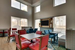 uma sala de jantar com mesa, cadeiras e janelas em Holiday Inn Express Hotel & Suites Jacksonville North-Fernandina, an IHG Hotel em Yulee
