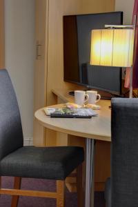 a table with a chair and a tv on a desk at Sure Hotel by Best Western Aberdeen in Aberdeen