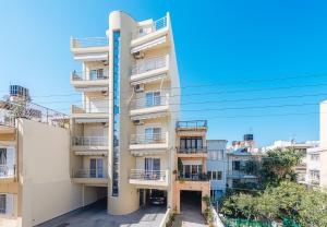 an apartment building with balconies and a blue sky at Creticum Suites in Heraklio Town