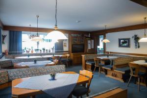 a restaurant with tables and chairs and a large window at Pension Millinger in Sankt Martin bei Lofer