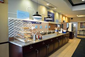 a restaurant with a bakery counter with pastries at Holiday Inn Express & Suites Youngstown West I 80, an IHG Hotel in Austintown