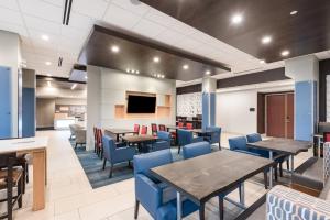 a dining room with tables and blue chairs at Holiday Inn Express Hotel & Suites Milton by IHG in Milton