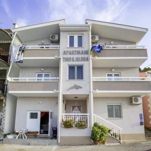 a white building with a sign on it at Apartments Tiho & Jelena in Blace