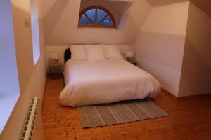 Schlafzimmer mit einem Bett mit weißer Bettwäsche und einem Fenster in der Unterkunft Chaumière d'Albâtre -Gîte-Détente nature et bien être in Ourville-en-Caux