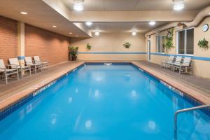 uma piscina num quarto de hotel com cadeiras em Holiday Inn Express Hotel & Suites 1000 Islands - Gananoque, an IHG Hotel em Gananoque