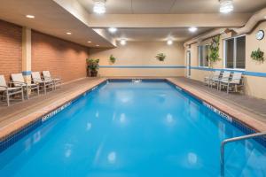 a swimming pool in a hotel room with chairs at Holiday Inn Express Hotel & Suites 1000 Islands - Gananoque, an IHG Hotel in Gananoque