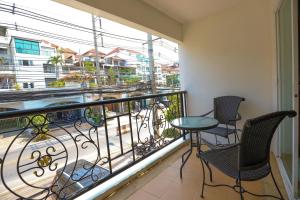 a balcony with chairs and a table and a view at Tara Court Hotel in Pattaya South