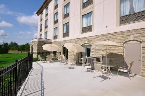 un patio exterior de un edificio con sillas y sombrillas en Holiday Inn Express Hotel & Suites Ottawa Airport, an IHG Hotel, en Ottawa