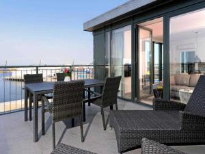 d'une terrasse avec une table et des chaises sur un balcon. dans l'établissement Ohlerich Speicher App_ 45, à Wismar
