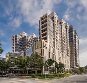 a tall white building with a clock on it at Park Avenue Clemenceau in Singapore