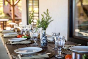 a wooden table with plates and glasses and a vase at Park Hotel Zolotaya Dolina in Korobitsyno