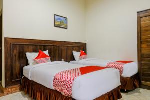 SUPER OYO 2643 Hotel Graha Prima tesisinde bir odada yatak veya yataklar