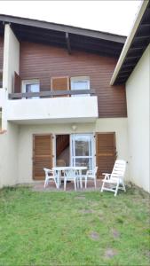 un patio con sedie e tavolo di fronte a una casa di Réf 272,Seignosse océan, Villa Patio à 150m de la plage, avec place de parking et piscine commune , 4 personnes a Seignosse