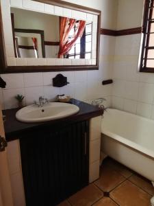 y baño con lavabo y bañera. en MixoSunrise Guesthouse & Spa, en Pretoria