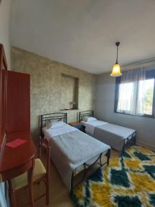 a room with two beds and a chair and a table at Ziakas Rooms in Zákas