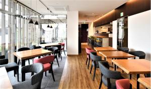 a restaurant with wooden tables and chairs and windows at HOTEL SOSHA in Ishioka