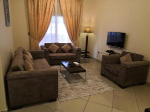 a living room with two couches and a tv at Boulevard City Suites Hotel Apartments in Dubai