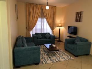 a living room with two couches and a television at Boulevard City Suites Hotel Apartments in Dubai