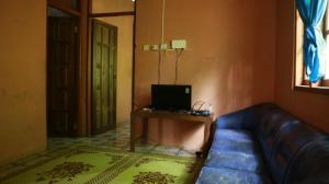 Homestay Jemiran في Sermo: غرفة معيشة بها أريكة وتلفزيون