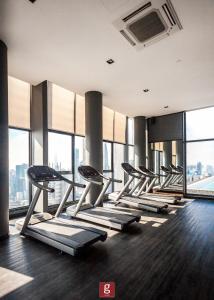 a row of treadmills in a gym with windows at EXPRESSIONZ KLCC BY G Suites in Kuala Lumpur