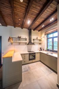 a large kitchen with wooden ceilings and a large island at Villa Buta in Valmiera