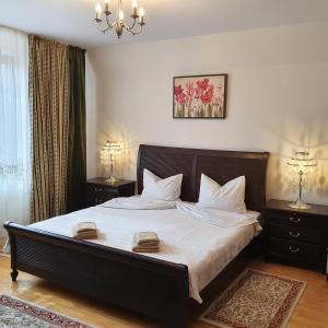 a bedroom with a large bed with two towels on it at Vila De la Lugas in Oradea