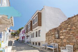 a street in a town with a stone building at Troas Ada Hotel in Bozcaada