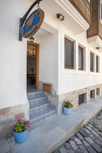 a building with two potted plants in front of it at Troas Ada Hotel in Bozcaada