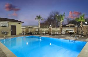 einen großen blauen Pool mit Tischen und Stühlen in der Unterkunft Staybridge Suites - Houston - Medical Center, an IHG Hotel in Houston