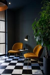 two chairs and a table in a room with a checkered floor at Avenida 60 by NÔMA in Aveiro