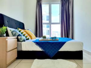 - une chambre avec un lit bleu et une fenêtre dans l'établissement Ara Damansara Pacific Place by BeeStay, à Petaling Jaya