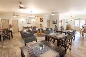a large living room with tables and chairs at The Belgium Inn in Hoedspruit