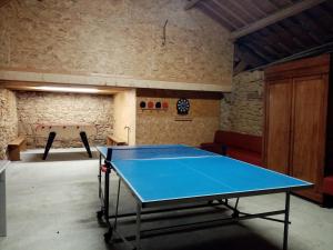 un tavolo da ping pong in una stanza con una palla da ping pong di les gites du grenit a La Chapelle-Neuve