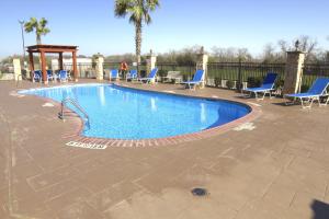 a swimming pool with chairs and a gazebo at Holiday Inn Express Seguin, an IHG Hotel in Seguin