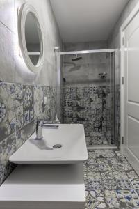 a bathroom with a sink and a shower at Troas Ada Hotel in Bozcaada