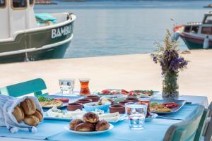 a blue table with food on it next to the water at Troas Ada Hotel in Bozcaada