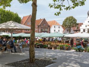 a market with people sitting at tables and umbrellas at Hotel-Restaurant Kolpinghaus in Lingen