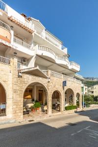 a large stone building with arches on a street at Villa Roko in Tučepi