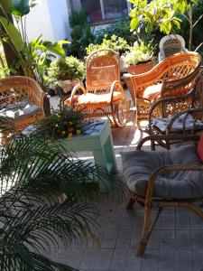un gruppo di sedie in vimini e un tavolo su un patio di Le Case di Vito a Favignana