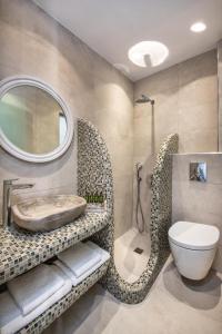 a bathroom with a sink and a toilet and a mirror at Nectarios Villa - Studios & Suites Adults Only in Fira