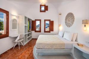 a bedroom with a bed and a desk and window at Nectarios Villa - Studios & Suites Adults Only in Fira +65 photos