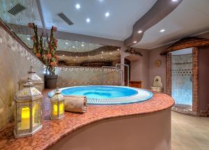 une grande salle de bains avec bain à remous dans l'établissement Hotel Pejo, à Peio Fonti