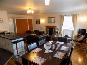 a living room with a kitchen and a table with chairs at Oakdene Apartments in Windermere