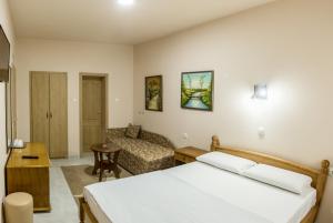 une chambre d'hôtel avec un lit et un canapé dans l'établissement B&B Passage, à Sremska Mitrovica