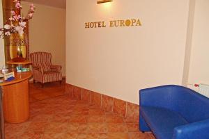 a hotel lobby with a blue couch and a chair at Hotel Europa in Jastrzębia Góra